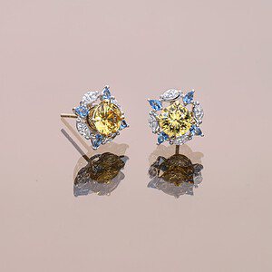 A pair of dazzling yellow zircons worn with blue and white jackets, from our ready-made collection.