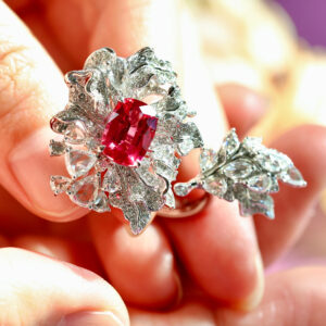 An electric red spinel, gloriously surrounded by a flower-shaped diamond halo.